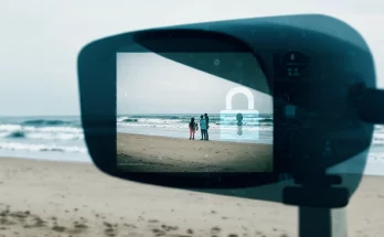 AI surveillance risks represented by a vacation photo at a beach, featuring waves and sand with a digital overlay of data points and privacy concern symbols, illustrating how AI can analyze personal images to track individuals.